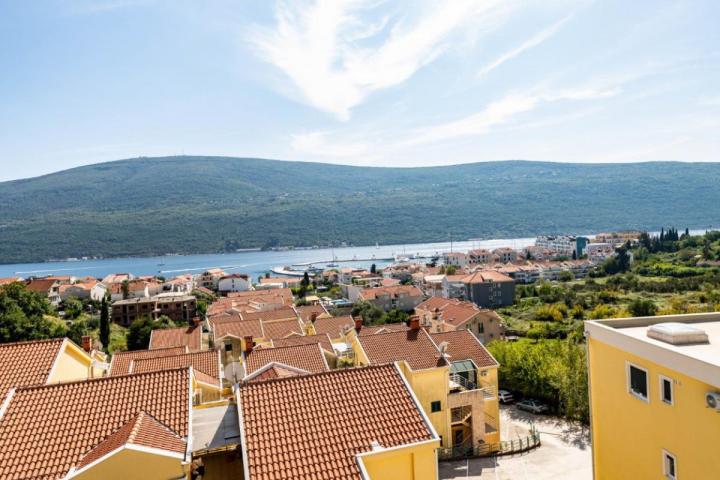 Novi stan sa 2 spavaće sobe i panoramskim pogledom na more u naselju. Djenovici