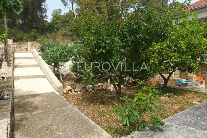 Maslinica, otok Šolta, dvojna kuća okružena zelenilom, položena na parceli površine 382 m²