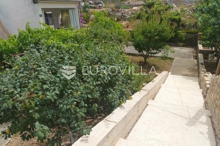 Maslinica, otok Šolta, dvojna kuća okružena zelenilom, položena na parceli površine 382 m²