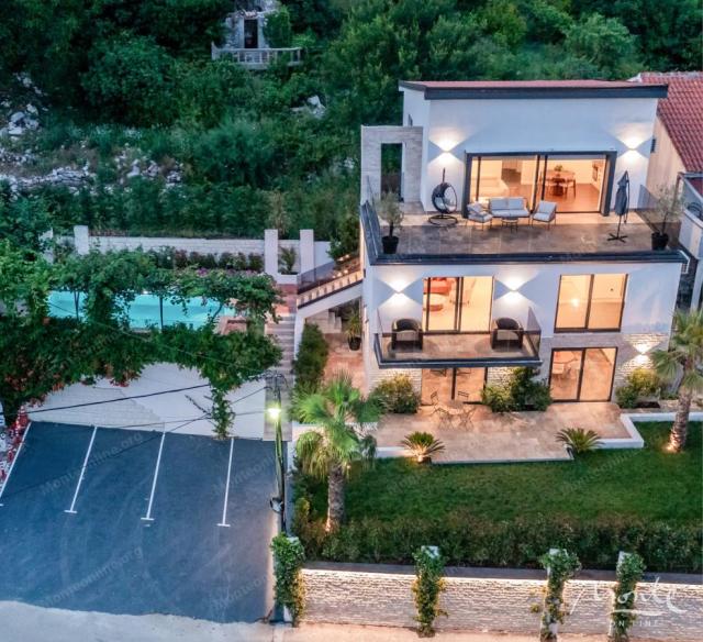 Villa La Costa u mirnom selu Markovići sa bazenom, tropskim palmama i elegantnim dizajnom