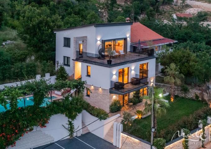 Villa La Costa u mirnom selu Markovići sa bazenom, tropskim palmama i elegantnim dizajnom